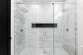 A large shower with marble subway tiles and a black hexagon tile shelf. Royalty Free Stock Photo