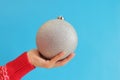 Large silver Christmas ball in a woman's hand