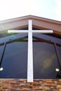 Large Silver Metal Cross Hanging on Steeple of Christian Church Building