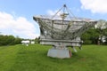 Large silver radio telescope antenna with two smaller antenna array