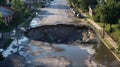 Large sinkhole in the middle of a city street Royalty Free Stock Photo