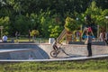 Large skate pool, teenager rides bike on steep slopes