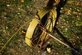 A large skein of yellow wire wound on an iron drum against a background of green grass and yellow autumn leaves. Equipment