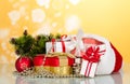 Large and small boxes in the header of Santa Claus, next to gift in heart shaped decorations for the Christmas tree, on yellow Royalty Free Stock Photo