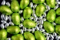 Large & small green, lime green and silver spring colours of foil wrapped chocolate easter eggs, against a black background. Royalty Free Stock Photo