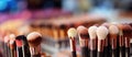 Large and small makeup brushes of various colors assembled in a bundle on the desktop. The concept of cosmetologist\'s tools.