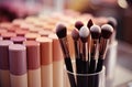 Large and small makeup brushes of various colors assembled in a bundle on the desktop. The concept of cosmetologist\'s tools.