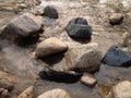 Large and small stones of different geometric shapes in the water.