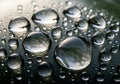 Large and small water droplets bead on a smooth, dark surface, Royalty Free Stock Photo