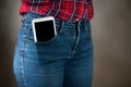 A large smartphone sticks out of a pocket tight-fitting girls jeans