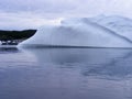 Large smooth iceberg in Twillingate Harbour with forested landscape on the horizon Royalty Free Stock Photo