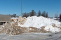 A large snowdrift in the parking lot. The truck in the parking lot got stuck in the snow. Cleaning roads from snow