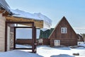 large snowdrift on roof of rural house. snow accumulated over winter slides off roof of wooden house