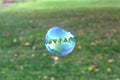 A large soap bubble in which nature is reflected