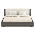 A large soft brown-beige double bed with pillows and a blanket on a white background. Front view copyspace. 3d rendering