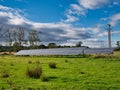 Large solar panels in farmland in north east England. Taken on a sunny day in Autumn with blue sky and light clouds