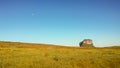 Large solitary mountain and the Moon seen from an immense plateau with vegetation typical of the Brazilian cerrado