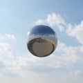 Large spherical mirror balloon floating against blue sky with clouds Royalty Free Stock Photo