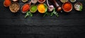 Large spice and herb collection in bowls and spoons. Indian spices. On a black wooden background. Royalty Free Stock Photo