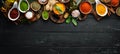 Large spice and herb collection in bowls and spoons. Indian spices. On a black wooden background.