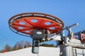 Large spinning wheel with electric cable hoist motor in a ski resort.