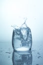 Large splash of water with bubbles, falling ice cube in a glass of water, single stack on a light background water splash Royalty Free Stock Photo