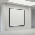 A large, square, blank white canvas with a thin black frame is mounted on a white wall. Royalty Free Stock Photo