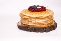 A large stack of pancakes with red sweet berries