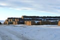 Large Stacks of Hay Bails on a Snowy Farm Field in Winter