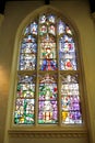 A large stained glass church window set in stone framework