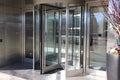 A large stainless steal and glass revolving door in front of an office building in downtown Atlanta