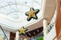 Large stars New Year Christmas decor in shopping mall interior, glass roof atrium. Pavlodar, Kazakhstan - 01.17.2023