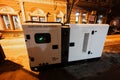 Large stationary diesel power three phase electric silent generator set in evening city