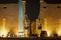 Statue and obelisk at entrance to Luxor Temple during night Royalty Free Stock Photo