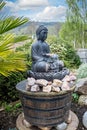 Large statue of sitting buddha - water feature in garden in Sidmouth, Devon, UK