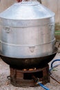 Large steamer, cooking equipment. Hot steamer pot and boiling water on charcoal stove or brazier. Traditional silver steamer pot Royalty Free Stock Photo