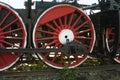 Large steel wheels of old steam locomotive red with white outline