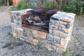 A large stone outdoor grill with a fire burning Royalty Free Stock Photo