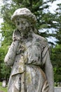 Large stone sculpture of weeping angel covered in moss in cemetery Royalty Free Stock Photo