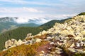 Large stones against the hill covered with fluffy white clouds