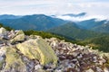 Large stones against the hill covered with white clouds Royalty Free Stock Photo