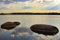 Large stones in the lake, clouds are reflected in the water, at sunset Royalty Free Stock Photo