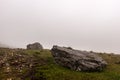 Large stones on a mountainside with fog in the background. Royalty Free Stock Photo