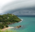 A large storm cloud over the sea near the island. The view from