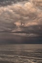 Large storm clouds on the Azov Sea, illuminated by the setting sun, the sea horizon. Reflection on the water surface.