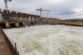 A large stream of water coming out from under the river bamboo on the Kolyma river during its construction