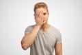 Large Studio portrait of a young light man t-shirt covering his face with a palm in the sign facepalm. Royalty Free Stock Photo