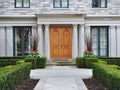 Large suburban house with stone columns and hedge