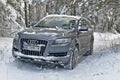 Large SUV Audi Q7 in a snowy forest.