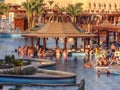 a large swimming pool with relaxing tourists from different countries on the inside of the hotel.